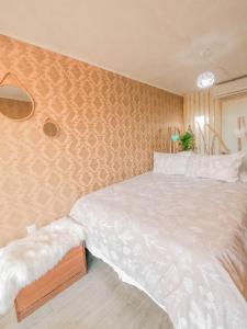 Un dormitorio con una gran cama blanca y una pared en AzulZenLodge en Paine