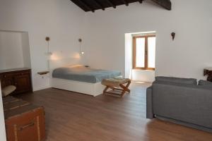 Quinta de Sobre a Fonte Charming Apartments في Fontelas: غرفة معيشة مع سرير وأريكة