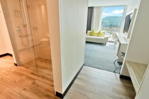 a bathroom with a shower and a living room at Sonesta Hotel Bucaramanga in Bucaramanga