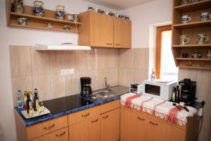 a kitchen with a sink and a microwave on a counter at AQUA Thermal Apartmanház II. in Püspökladány