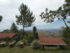 a wooden bench sitting on top of a hill at Cabañas Don Camilo Albergue de Montaña in Cabecera de Cañas