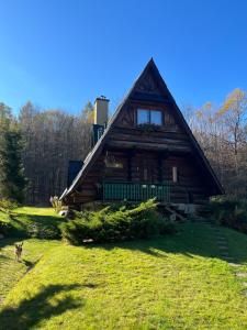 a dog walking in front of a log cabin at Kosarzówka in Bielsko-Biała