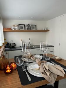a table with plates and wine glasses on it at The Lighthouse Cabin in Noordwijk
