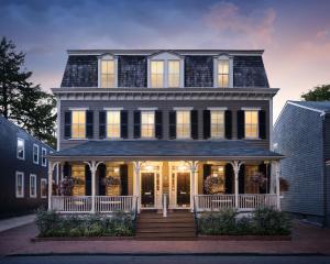 a large house with a front porch with lights on at Flag House Inn in Annapolis