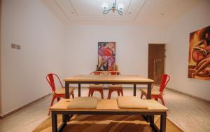 a table and chairs in a room with a painting at Big chill stays in Accra