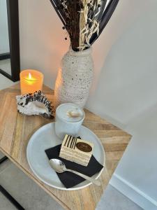 een tafel met een bord eten en een vaas bij The Lighthouse Cabin in Noordwijk