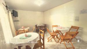 comedor con mesas y sillas y TV en Casa da Amizade Pousada, 200 mt do Beto Carrero, en Penha