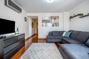 uma sala de estar com um sofá e uma televisão de ecrã plano em Sunny and Bright Corcovada, T1 with Large Terrace, Albufeira em Albufeira