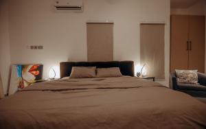1 dormitorio con 1 cama grande y 1 silla en Big chill stays, en Accra