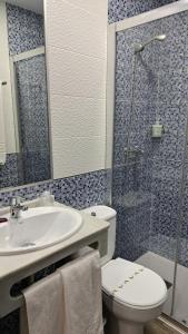 y baño con aseo, lavabo y ducha. en Hostal Maria Jose, en Conil de la Frontera