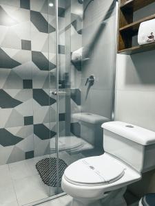 a bathroom with a toilet and a glass shower at Hotel Cisne in Cuenca