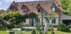 a house with a statue in front of it at Bergerie Bracquetuit in Bracquetuit