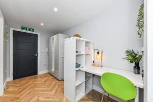 een kamer met een bureau en een groene stoel bij The Varsity Studios in Nottingham