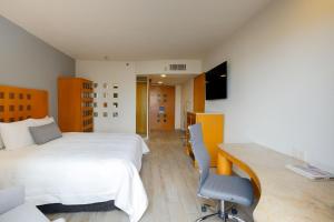 - une chambre avec un lit, un bureau et un ordinateur dans l'établissement Real Inn Torreon, à Torreón