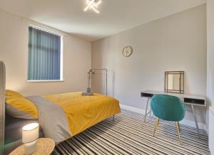 a bedroom with a bed and a desk and a chair at Lindsay House - South Manchester Stylish Townhouse With Free Parking in Manchester