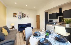 a living room with a table and a couch at Lindsay House - South Manchester Stylish Townhouse With Free Parking in Manchester