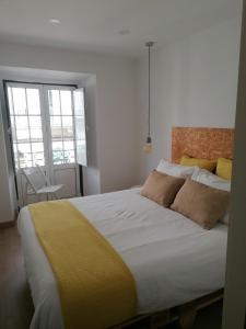 a bedroom with a large bed with a yellow blanket at Lisboa Bridge Spot in Lisbon