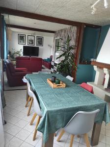 Maison de village avec exterieur في Oysonville: طاولة طعام عليها قطعة قماش من الطاولة الخضراء