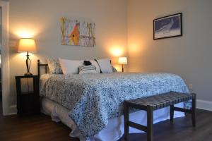a bedroom with a bed with a blue and white blanket at The Lofts at GFC in Galveston