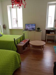 Habitación con cama, mesa y TV. en Forte Sangallo Home en Civita Castellana