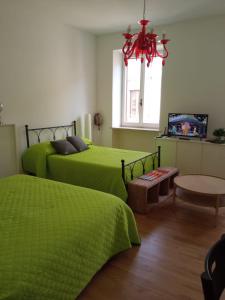 1 dormitorio con 2 camas verdes y ventana en Forte Sangallo Home en Civita Castellana