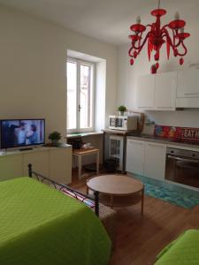 sala de estar con cocina con mesa y lámpara de araña en Forte Sangallo Home - PARKING POINT FOR BIKE, en Civita Castellana