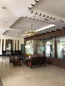 a lobby with benches and tables and a chandelier at Aisis Home at Afamosa in Kampong Alor Gajah