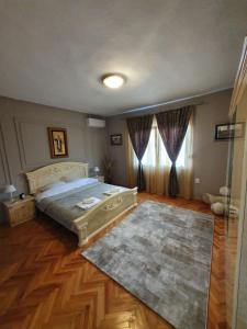 Schlafzimmer mit einem Bett und Holzboden in der Unterkunft Green House Pejovic in Podgorica