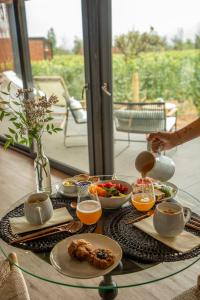 a table with food and drinks on a glass table at Vibo Wine Lodge At Viu Manent in Santa Cruz