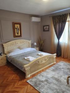 a bedroom with a large white bed and a window at Green House Pejovic in Podgorica