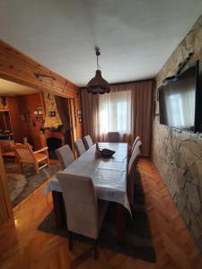 ein Esszimmer mit einem Tisch und einer Steinmauer in der Unterkunft Green House Pejovic in Podgorica