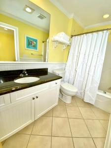 y baño con lavabo, aseo y espejo. en Island Inn of Atlantic Beach, en Atlantic Beach