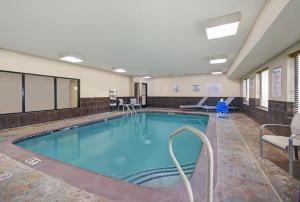 una gran piscina en una habitación con sillas y mesa en Holiday Inn Express Adrian, an IHG Hotel, en Adrian