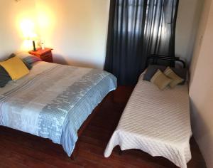 a bedroom with two beds and a window at La Paisanita Gualeguaychú #lapaisanitagchu in Gualeguaychú