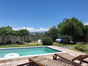 una piscina en un patio con un coche aparcado en Casa al Pie de los Andes en Luján de Cuyo