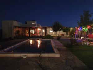 una piscina frente a un edificio por la noche en Casa al Pie de los Andes en Luján de Cuyo