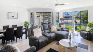 a living room with a couch and chairs and a table at Anchorage Waterfront unit in Yamba in Yamba
