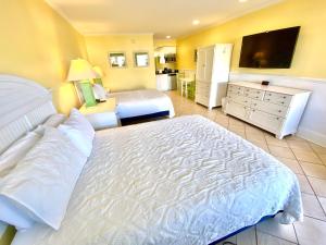 1 dormitorio con 1 cama grande y TV en Island Inn of Atlantic Beach, en Atlantic Beach