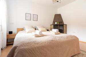 a white bedroom with a large bed with white sheets at Danube Living Collection - Wachau Willendorf - Villa Venus in der Wachau in Willendorf in der Wachau