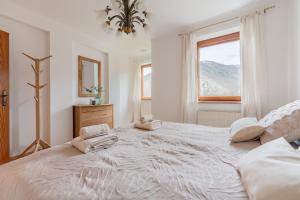a white bedroom with a large bed with towels on it at Villa Venus in Willendorf in der Wachau