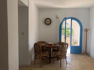 a dining room with a table and chairs and a clock at Villa Azul Beach in Piles