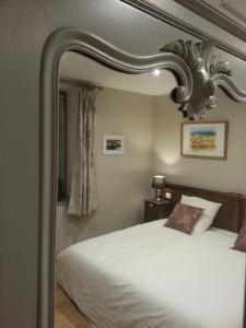 1 dormitorio con cama y espejo grande en Relais St Jacques - Roanne, en Saint-Haon-le-Châtel