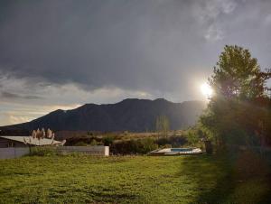 una vista de un campo con el sol en el cielo en Vista los Andes en Cacheuta