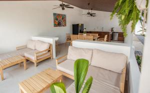 ein Wohnzimmer mit einem Sofa und einem Tisch in der Unterkunft Hotel Por Que No? in Uvita