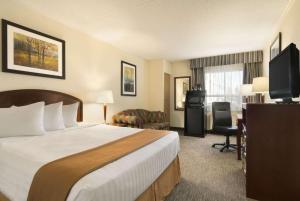 a hotel room with a bed and a television at Travelodge by Wyndham Edmonton South in Edmonton