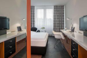 um quarto de hotel com uma cama e uma televisão em Dorint Kongresshotel Düsseldorf/Neuss em Neuss