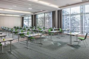 une salle de classe avec des tables et des chaises dans une salle avec des fenêtres dans l'établissement Dorint Kongresshotel Düsseldorf/Neuss, à Neuss