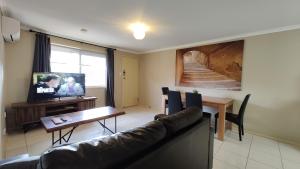 sala de estar con sofá, mesa y TV en 2 Bedroom 3 Bed Villa Inner City, en Toowoomba
