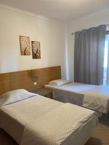 a room with two beds and a window at Castelos da Rocha in Portimão