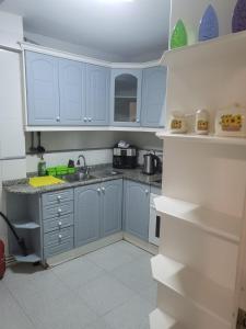 una cocina con armarios azules y fregadero en El Campello, en El Campello
